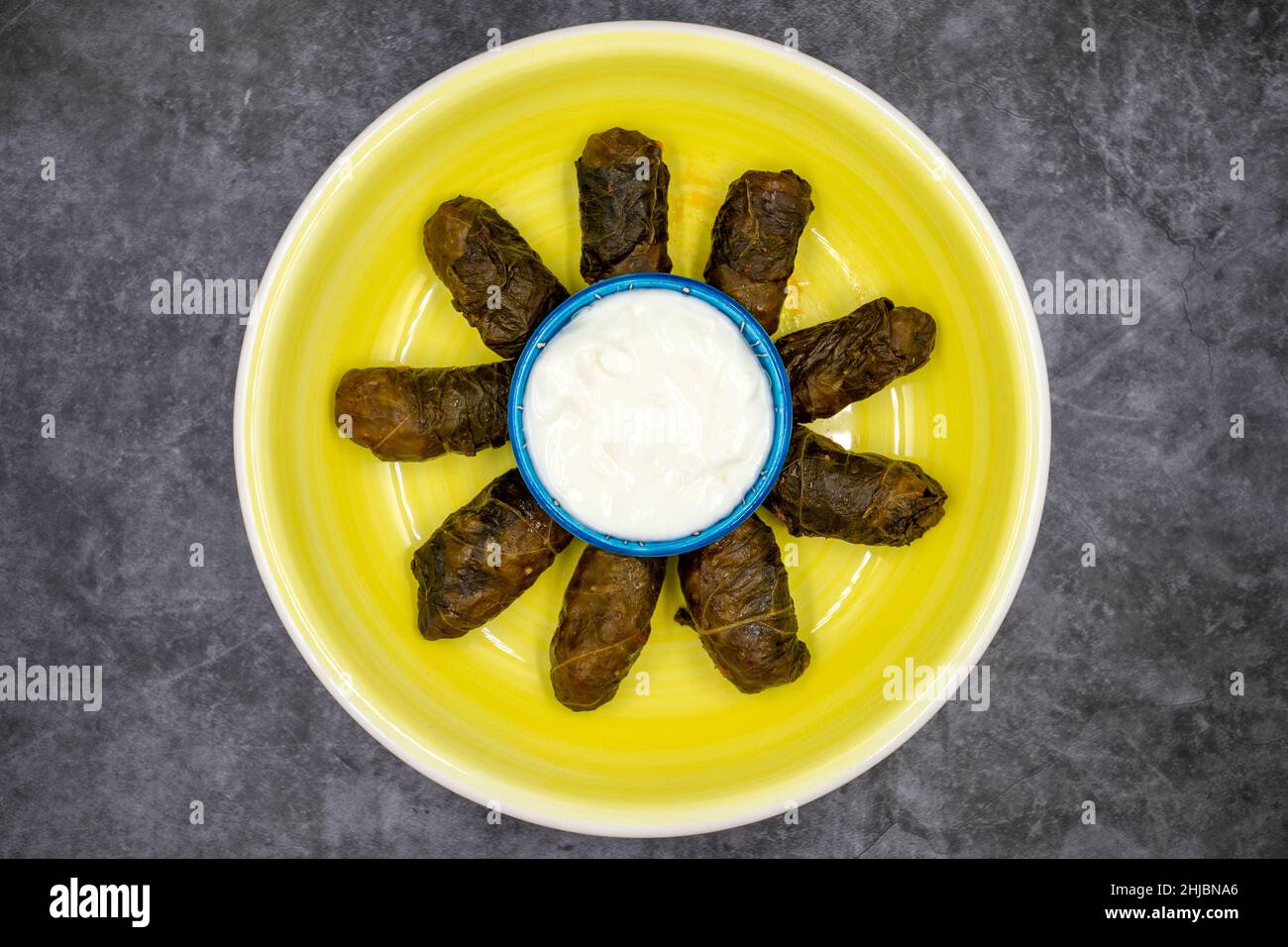 Confezionamento di foglie di carne. Sapore mediterraneo tradizionale. Foglie avvolte con yogurt su sfondo scuro. Nome locale etli yaprak sarma Foto Stock