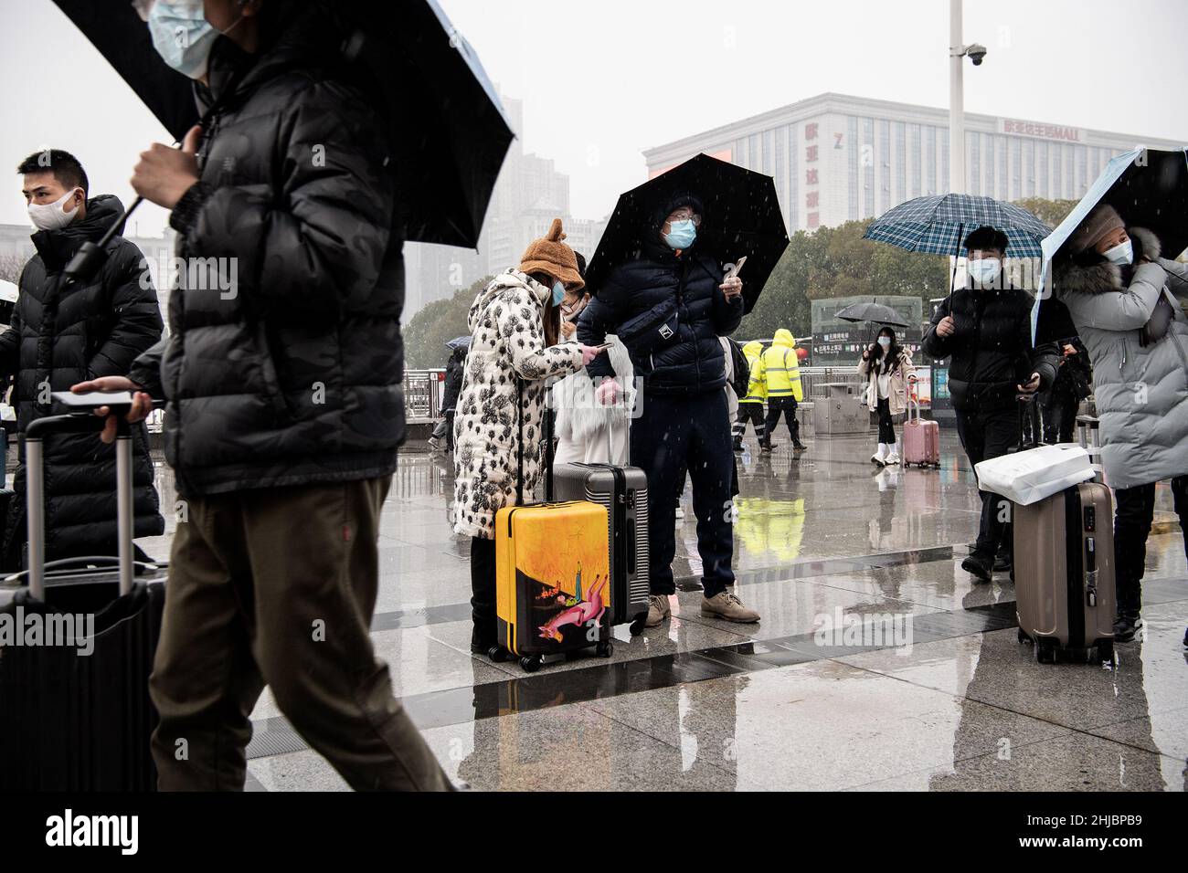 Wuhan, Cina. 28th Jan 2022. I passeggeri che indossano le maschere camminano nella nevicata alla stazione ferroviaria di Hankou a Wuhan.Un totale di 2,8 miliardi di viaggi passeggeri sono attesi durante i 40 giorni 'Chunyun, ' o Spring Festival corsa, che ha iniziato dal 17 gennaio di quest'anno. Milioni di cinesi si recheranno a casa per visitare le famiglie in massa durante il periodo di festa di Primavera che inizia con il Capodanno lunare il 1 febbraio. Credit: SOPA Images Limited/Alamy Live News Foto Stock