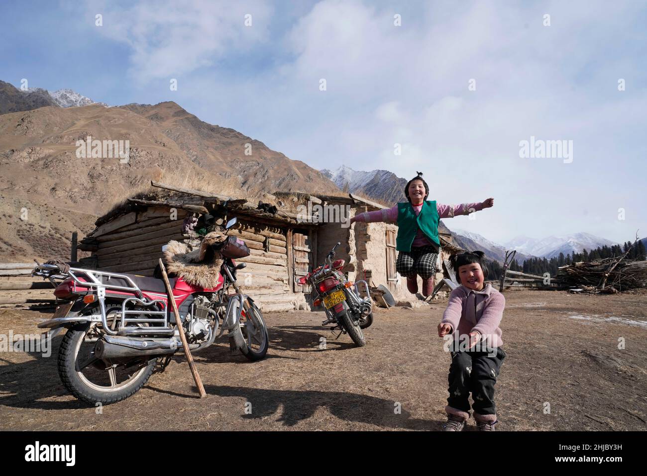 (220128) -- URUMQI, 28 gennaio 2022 (Xinhua) -- due bambini giocano intorno alla loro casa nella valle di Akyaz nella contea di Zhaosu, Prefettura autonoma di Kazak di Ili, regione autonoma di Xinjiang Uygur della Cina nord-occidentale, 26 gennaio 2022. Akyaz Valley è un importante pascolo invernale per i pastori di Zhaosu. Ogni anno, i pastori migravano lungo il fiume Akyaz, guidando con loro oltre 500.000 capi di bestiame per stabilirsi nella valle per l'inverno. Con un'altitudine media di 3.000 metri, la valle di Akyaz ha abbondante erba, acqua e un clima più caldo, grazie alle montagne circostanti che bloccano i venti freddi. In re Foto Stock
