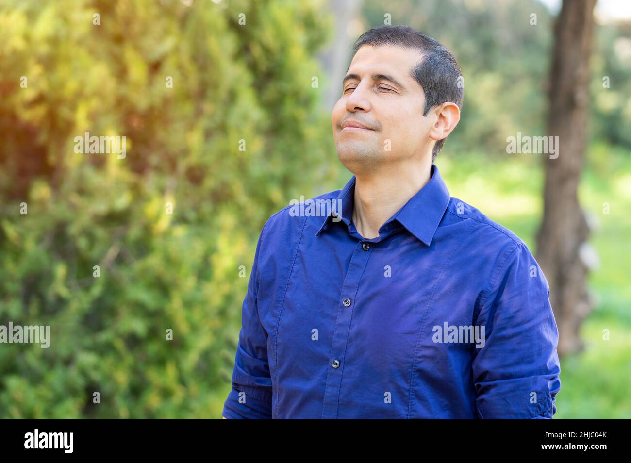 Uomo adulto rilassato respirando aria fresca in una foresta Foto Stock