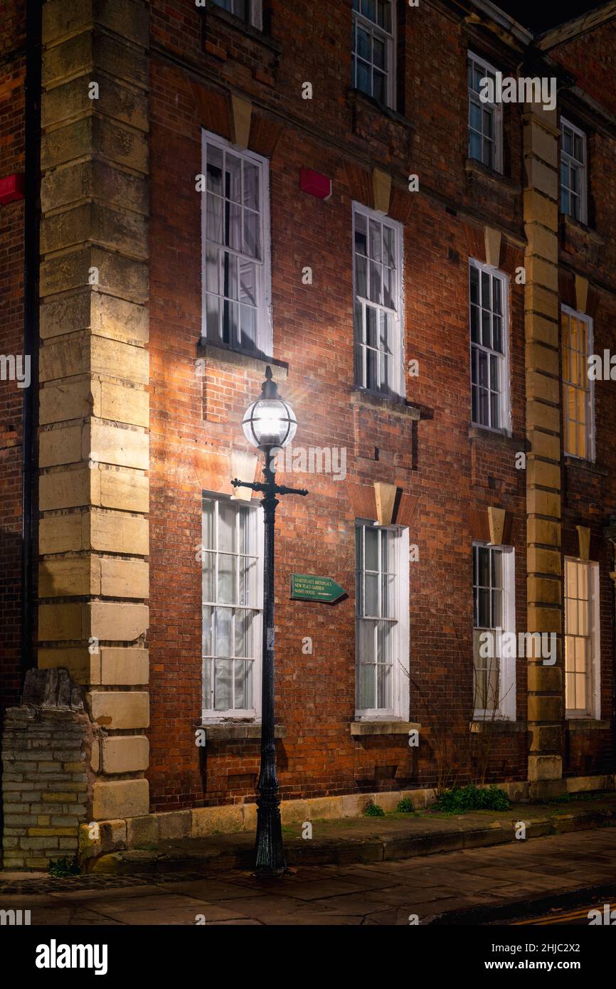Il vecchio edificio della scuola del college Trinity e lampione lungo Church Street di notte. Stratford upon Avon, Warwickshire, Inghilterra Foto Stock