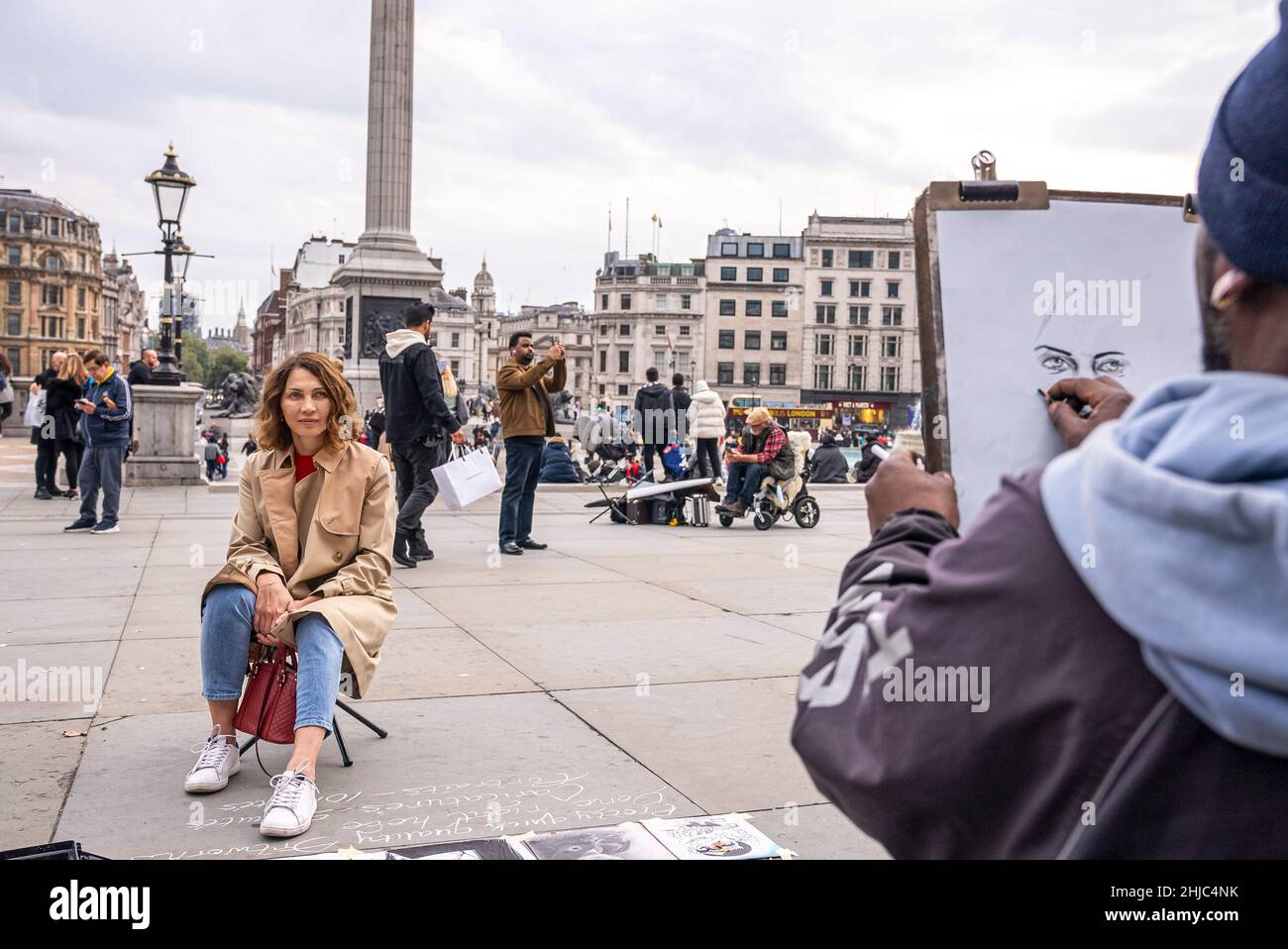 Artista di strada che disegna un ritratto di una donna a piazza trafalgar Foto Stock