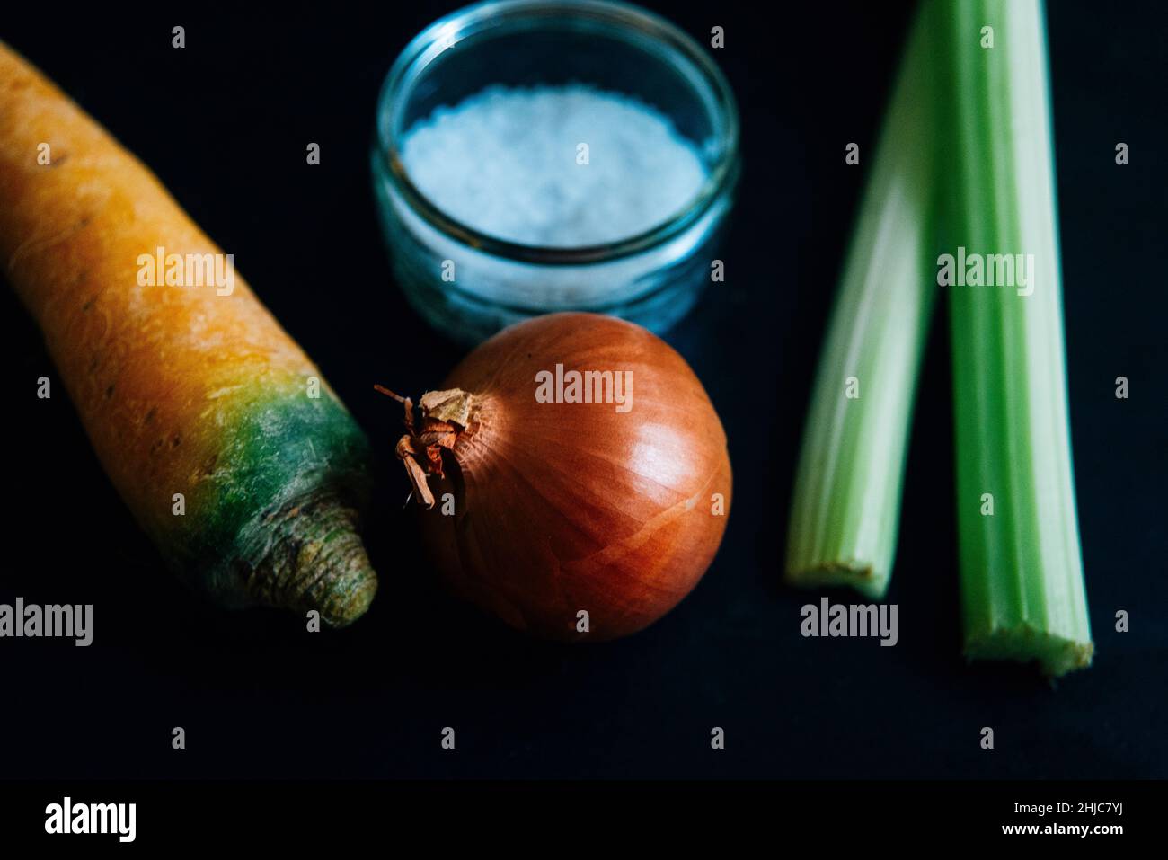 Sedano, carota e cipolla su ardesia con sale su ardesia. Ingredienti tradizionali per la base culinaria francese mirepoix, o soffritto italiano Foto Stock