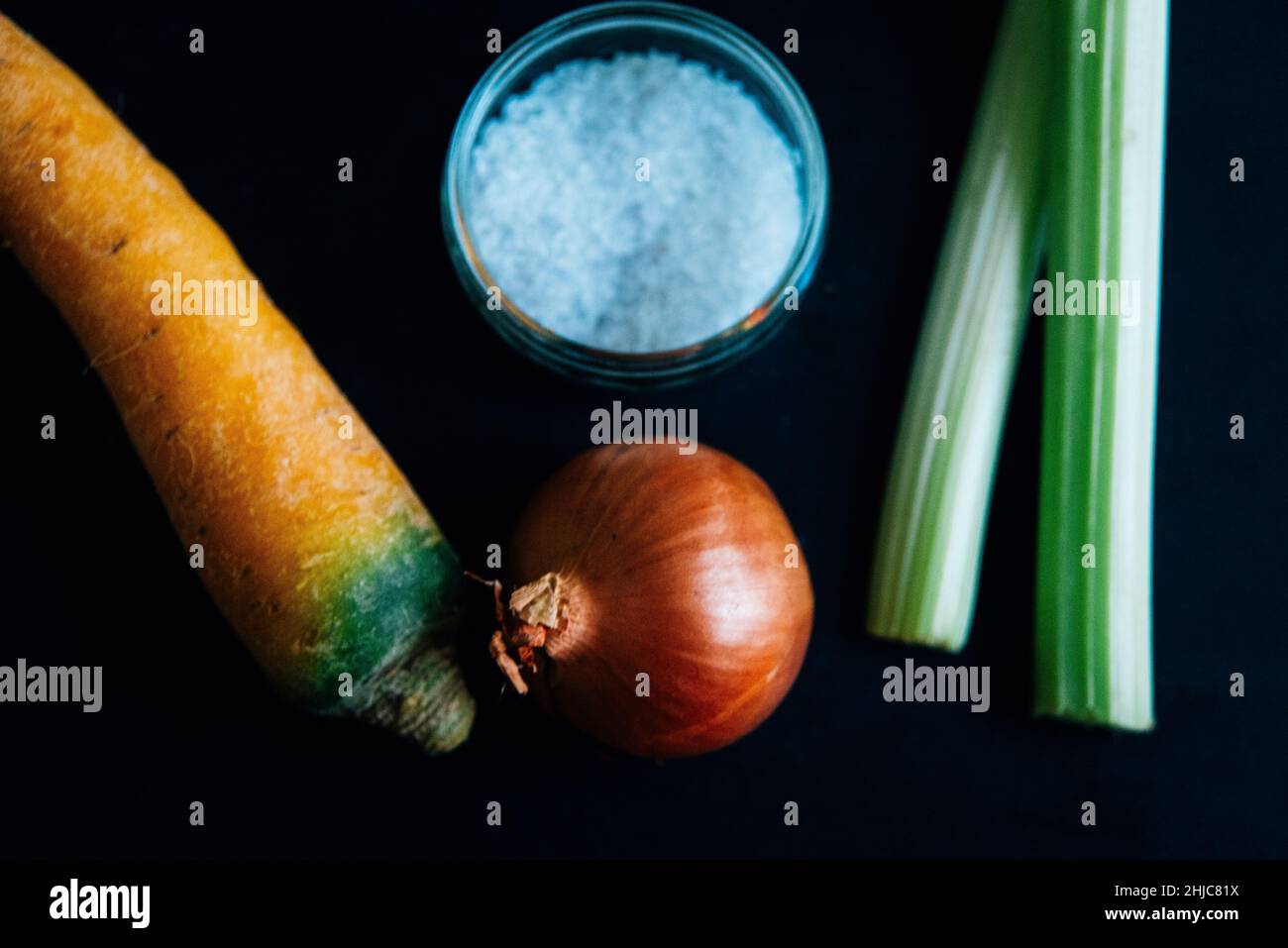 Sedano, carota e cipolla su ardesia con sale su ardesia. Ingredienti tradizionali per la base culinaria francese mirepoix, o soffritto italiano. bol. SPAG Foto Stock