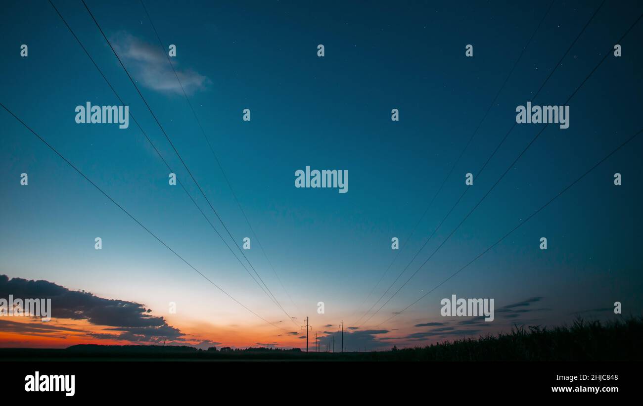 Tramonto Sky Transit a Dark Night Starry Sky con stelle scintillanti e percorso di traccia meteorico. Paesaggio con linee elettriche in Starry Sky Foto Stock