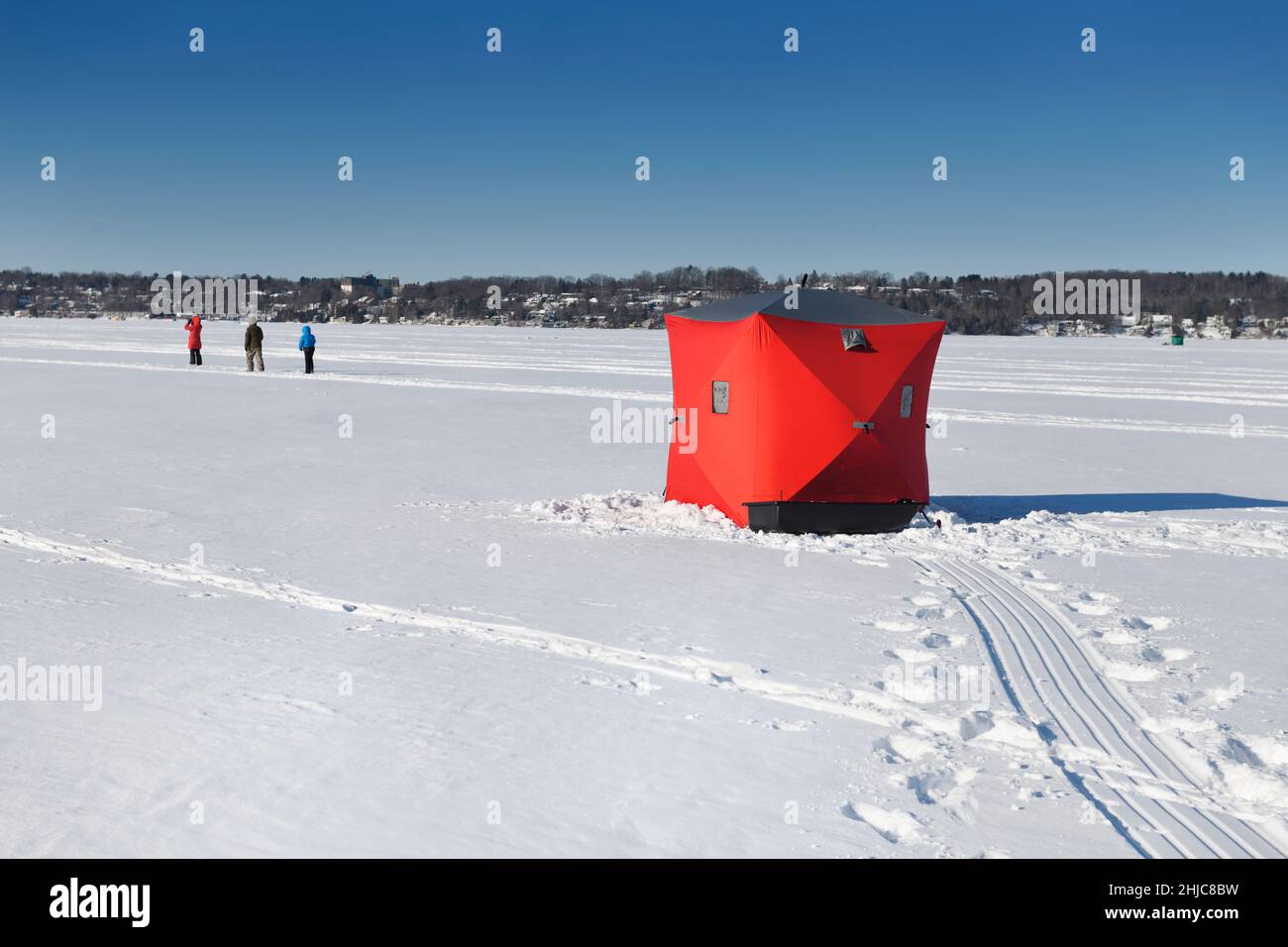 Escursioni in famiglia sul lago ghiacciato e tenda da pesca sul ghiaccio rosso sulla baia di Kempenfelt del lago Simcoe in inverno Barrie Ontario Canada Foto Stock