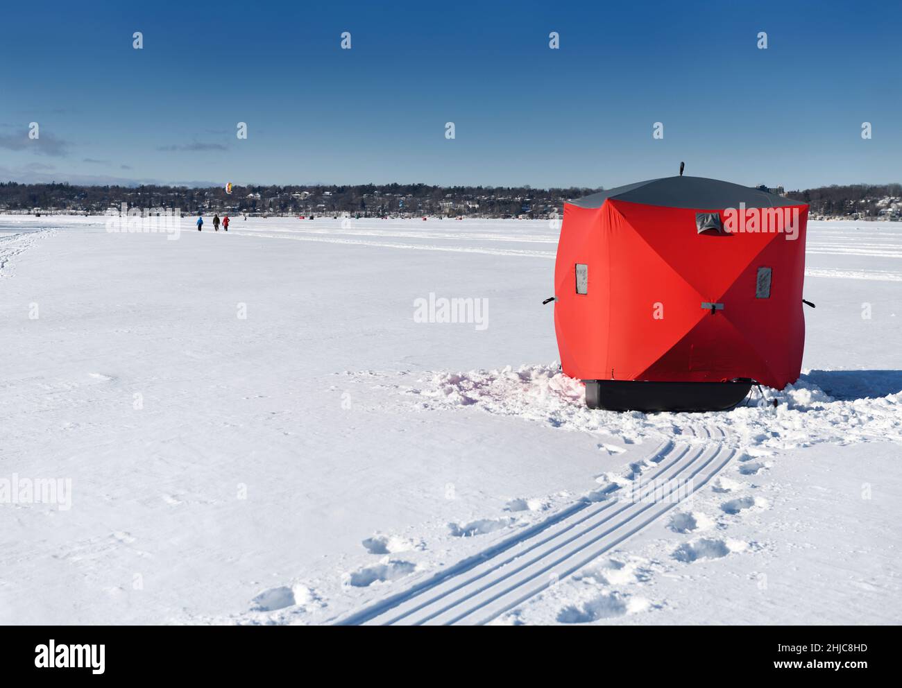 Attività all'aperto sul lago ghiacciato coperto di neve e sulla tenda da pesca sul ghiaccio rosso nella baia di Kempenfelt del lago Simcoe in inverno Barrie Ontario Canada Foto Stock