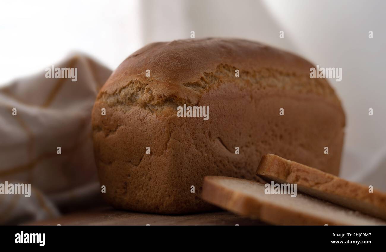pane fatto in casa su un tagliere con fette e un tovagliolo a scacchi Foto Stock