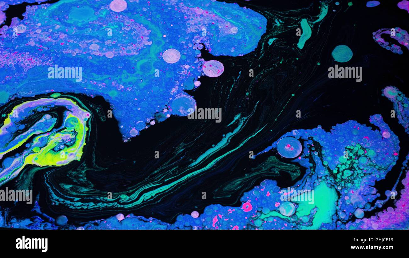 Arte fluida brillante con colori acidi e bolle. Riprese in stock. Schemi di miscelazione di liquidi di colori brillanti con bolle su una superficie piana. Acido colorato Foto Stock