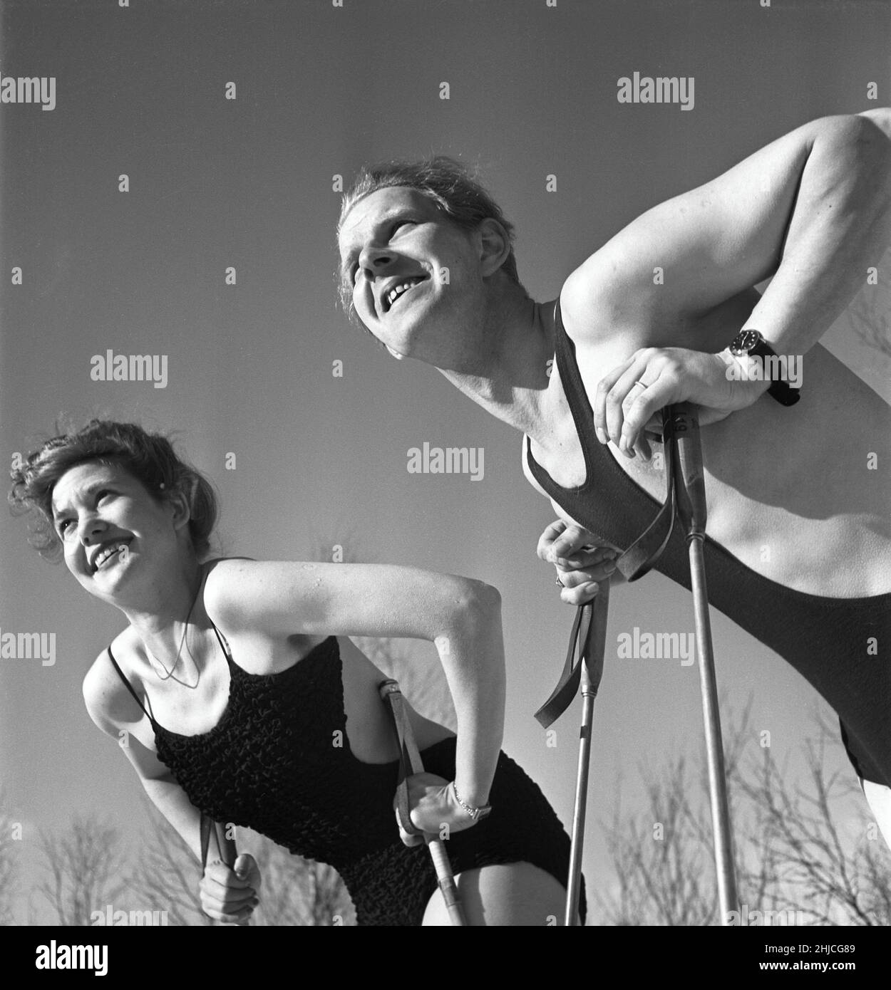 Inverno nel 1940s. Una coppia giovane sta godendo la loro vacanza di inverno e stanno portando i loro costumi da bagno per ottenere un'abbronzatura piacevole da essere all'aperto nel sole caldo. La moda degli uomini che avevano una tuta da bagno coprente era una reliquia dall'inizio del 20ths secolo, quando uomini e donne condividevano i bagni in laghi e mare. Sembravano un po' come un vestito da lottatori. Con il passare del tempo questa moda stava cominciando ad essere obsoleta, i banditi divennero più sottili e alla fine scomparsi e furono usati i più moderni bauli da nuoto. Svezia 1943. Foto Kristoffersson Rif D115-3 Foto Stock