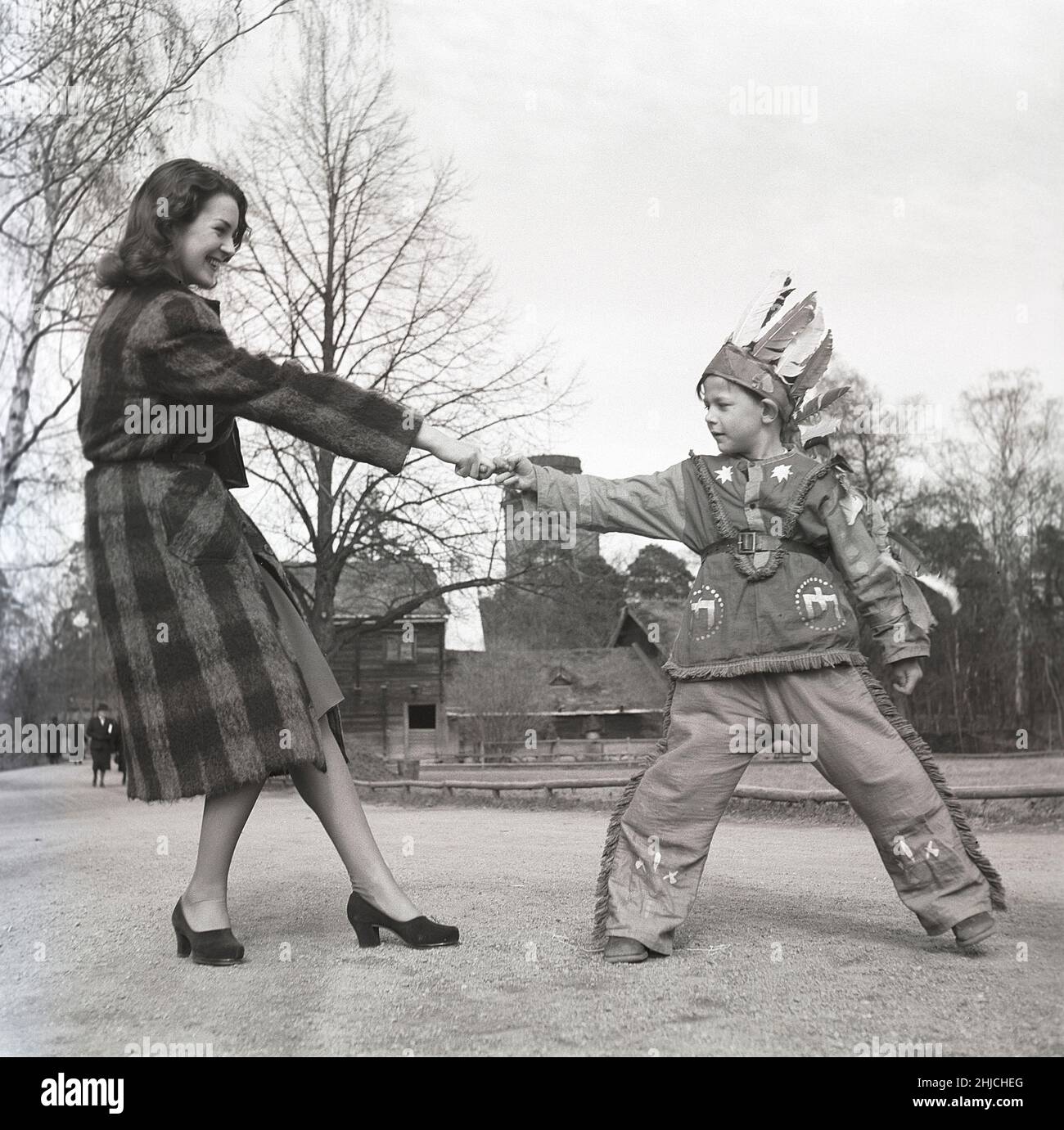 Nel 1940s. Un giovane uomo e un ragazzo vestito come indiano gioca insieme Fingel tirando, uno sport praticato in molte regioni e paesi. Tirando le dita, entrambi gli avversari si siedono a un tavolo opposto e cercano di tirare l'avversario verso se stessi sopra il tavolo con un dito. Con la forza fisica, superando il dolore del dito che viene teso e con la tecnica appropriata, l'avversario può essere sconfitto. Svezia 1942 Kristoffersson Ref A27-2 Foto Stock