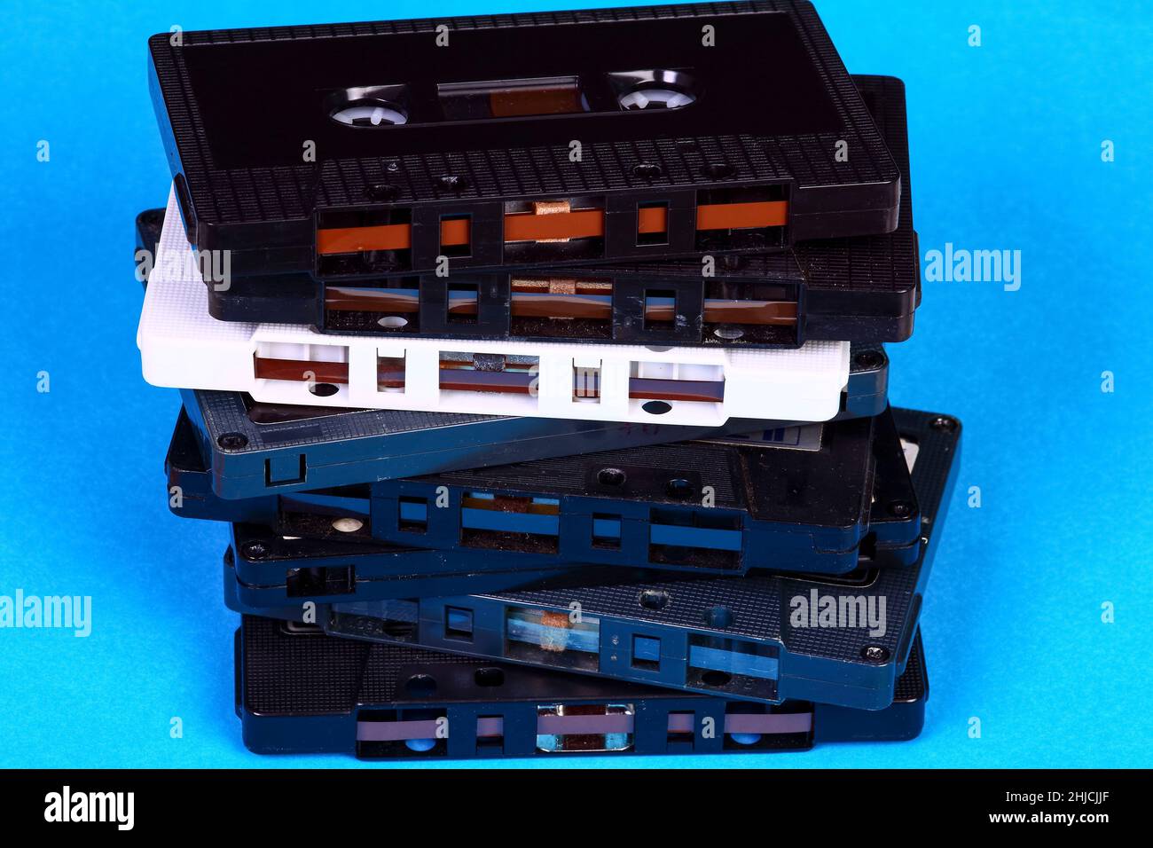 Pila di vecchie cassette audio retrò d'epoca isolate su sfondo blu Foto Stock