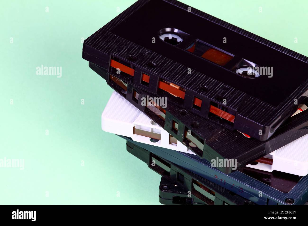 Pila di vecchie cassette audio retrò d'epoca isolate su sfondo verde Foto Stock