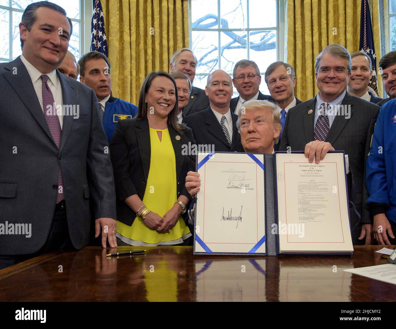 Il presidente Donald Trump presenta il firmato NASA Transition Authorization Act del 2017, affiancato dal senatore Ted Cruz (Texas), a sinistra, e da altri membri del Congresso. Foto Stock