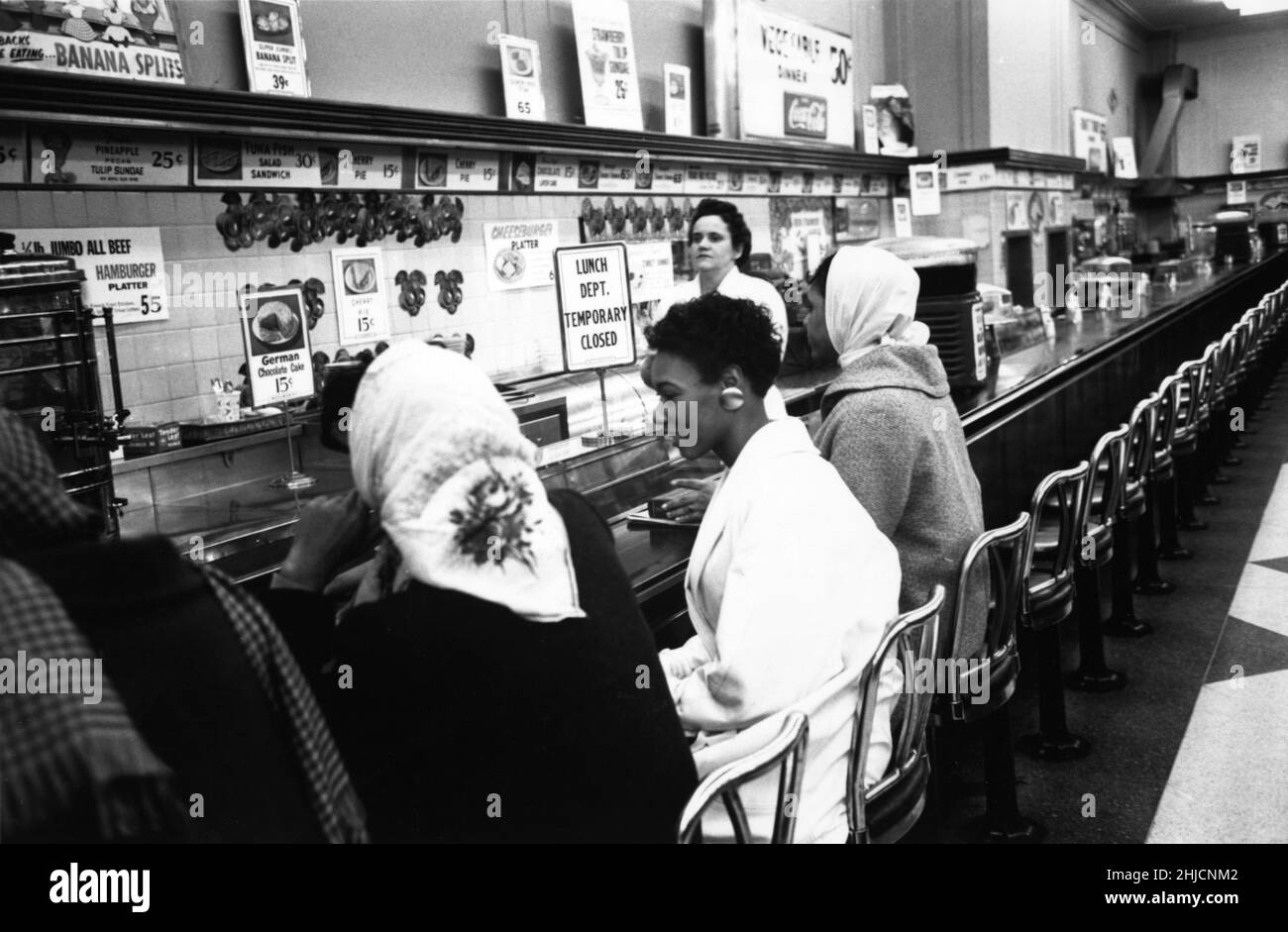 9 febbraio 1960, Charlotte, NC. Gli studenti avevano detto al capo della polizia cosa avrebbero fatto in anticipo. Il capo della polizia aveva promesso di non fare arresti se l'hanno fatto in modo ordinato e ha mantenuto la sua parola; nessuna polizia è mai apparsa ai sit-ins di Charlotte e non ci sono stati arresti. Dopo alcune ore, gli studenti sono partiti e i negozi hanno messo in su i cartelli che dicono che i loro banchi pranzo sono stati temporaneamente chiusi. Il 3rd luglio, i banchi di Woolworth sono stati riaperti a tutti. Foto Stock