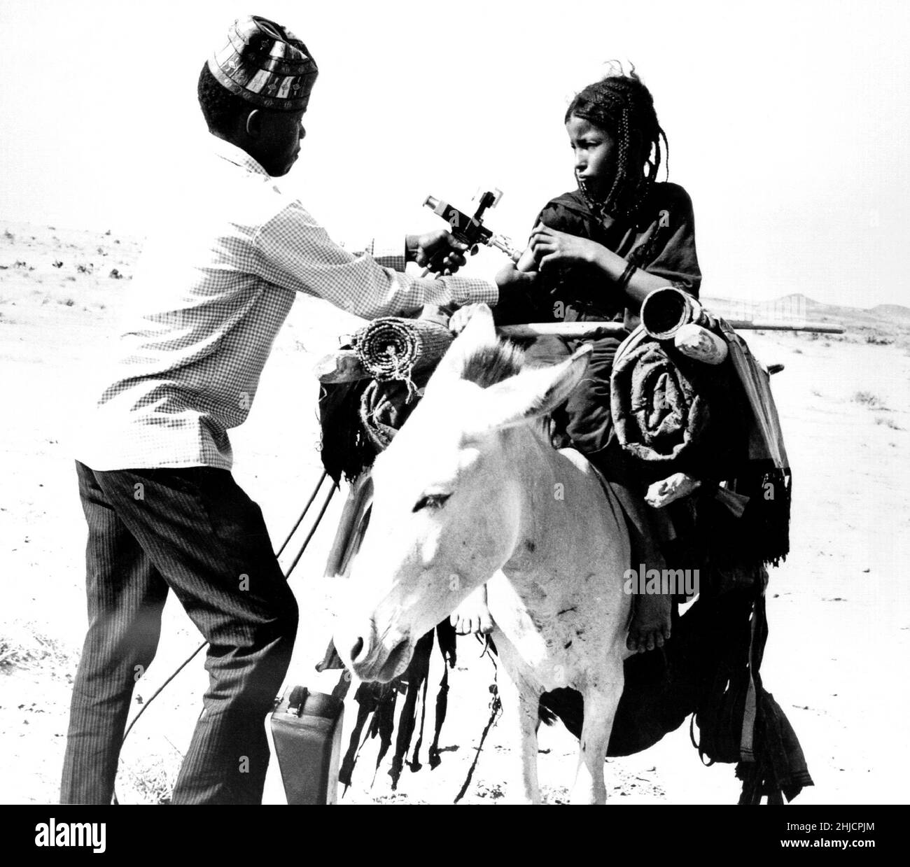 Questa ragazza nomade Tuareg sta ricevendo una vaccinazione contro il vaiolo in questa foto scattata nel 1967 in Mali, Africa occidentale. L'ultimo caso mondiale di vaiolo è stato documentato come avvenuto in Africa nel 1977. Nel 1980, L’OMS ha dichiarato l’eradicazione globale del vaiolo a causa di una campagna di vaccinazione a livello mondiale. L'OMS ha quindi raccomandato che tutti i paesi cessino la vaccinazione. Foto Stock