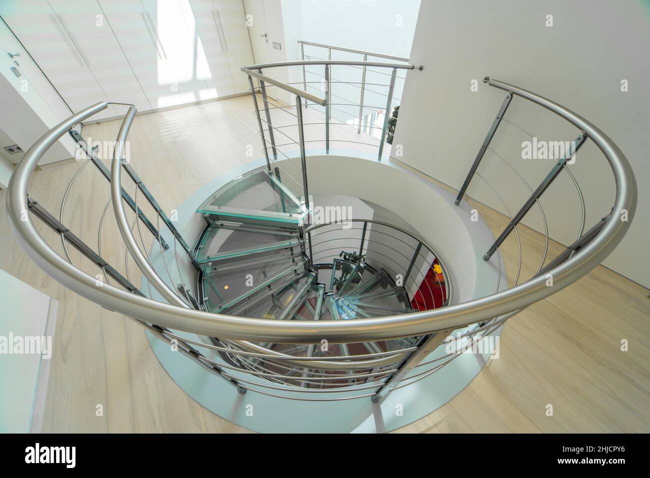 Interni moderni di casa privata di lusso. Scala a chiocciola in vetro e metallo. Foto Stock
