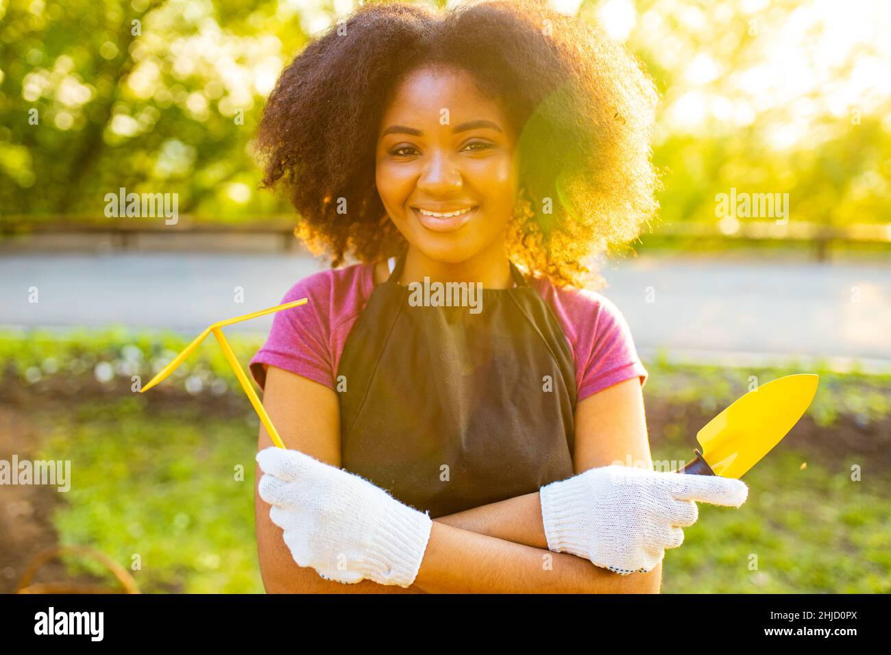 donna brasiliana con cool afro riccioli acconciatura in giardino primavera al tramonto Foto Stock