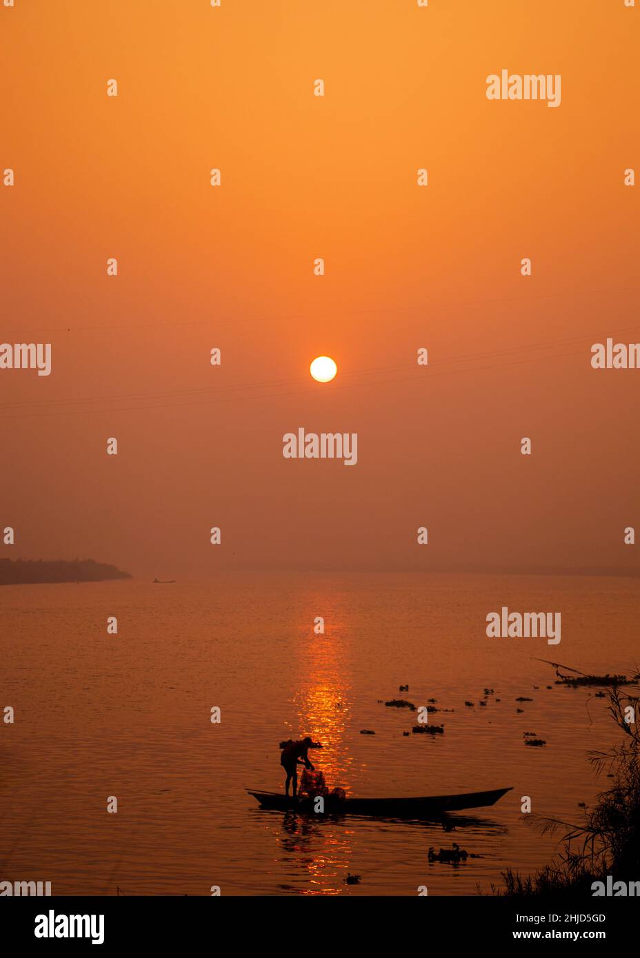 Un pescatore che pesca in barca nella mattinata d'inverno nebbiosa. Ho catturato questa immagine il 17 gennaio 2022, dal Bangladesh, Asia meridionale Foto Stock