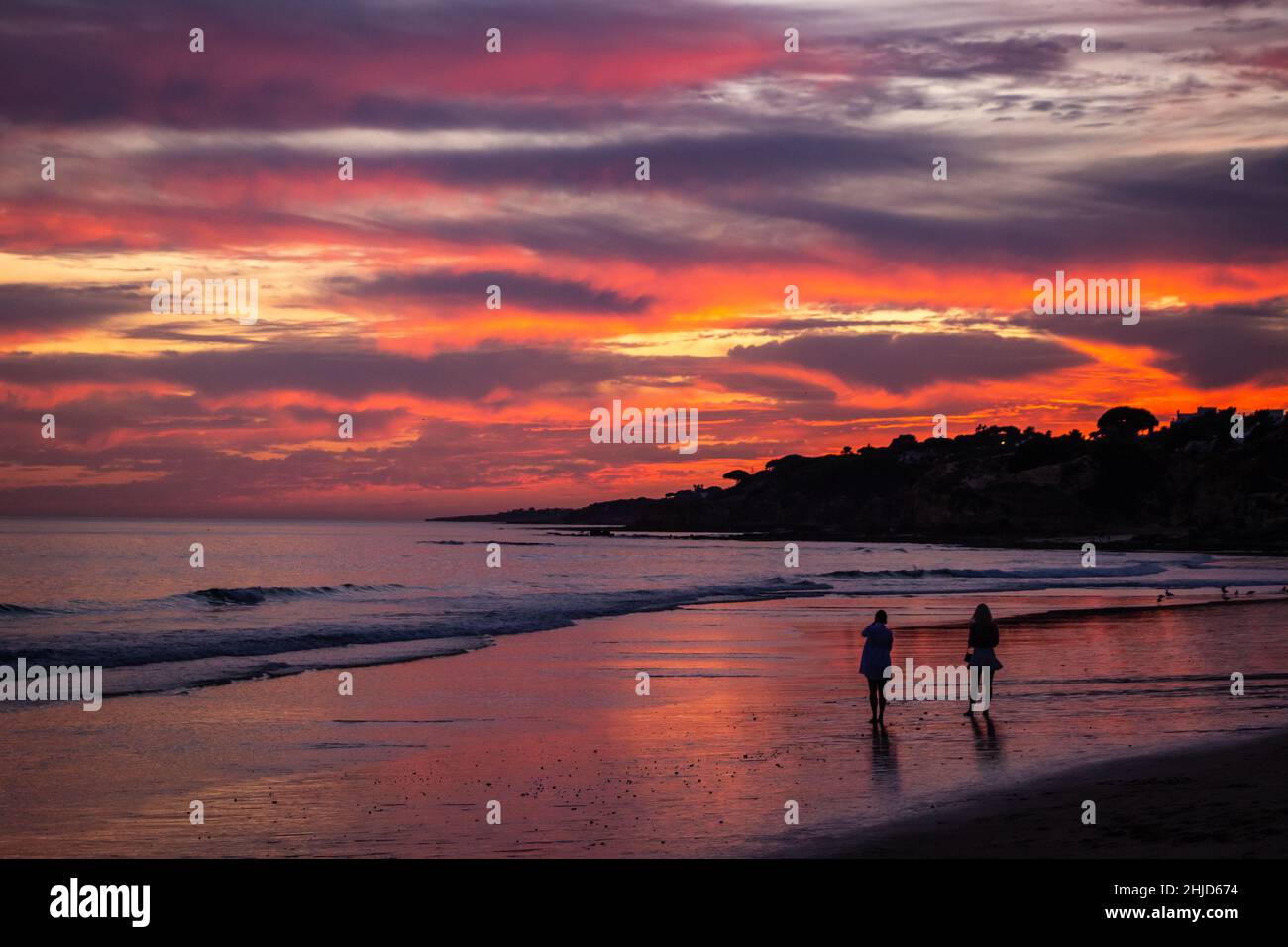 Un tramonto panoramico su una spiaggia atlantica sull'Algarve Portoghese. Foto Stock