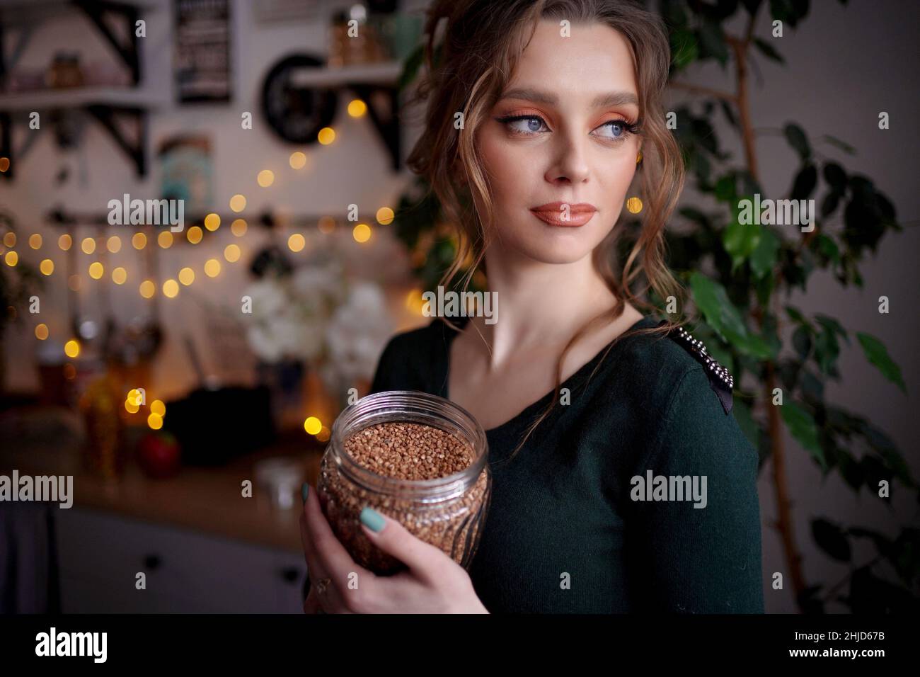 ragazza con una lattina di grano saraceno Foto Stock