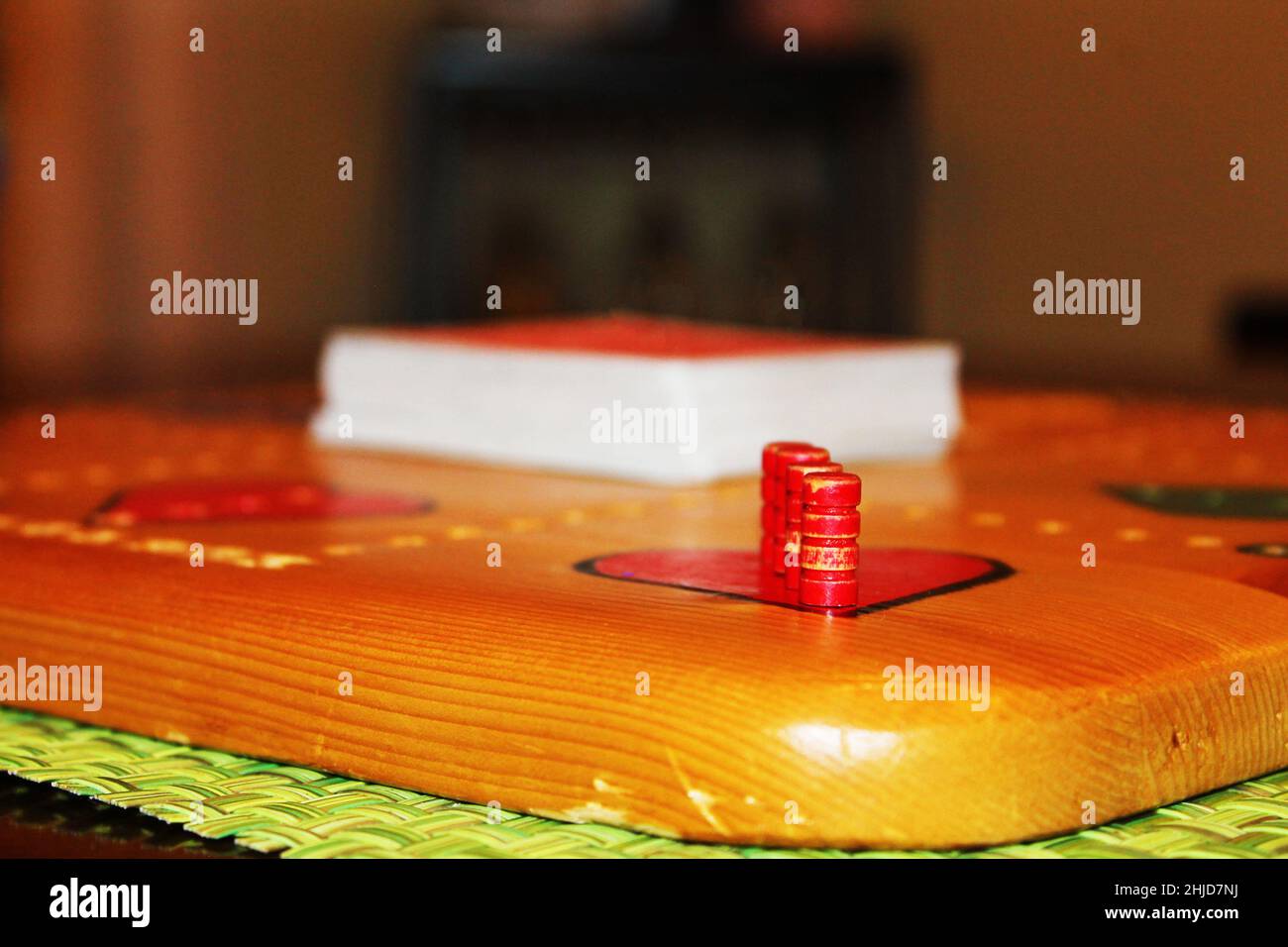 Primo piano di pioli in un tabellone Wampoo. Un mazzo di carte si trova al centro del tabellone. Foto Stock