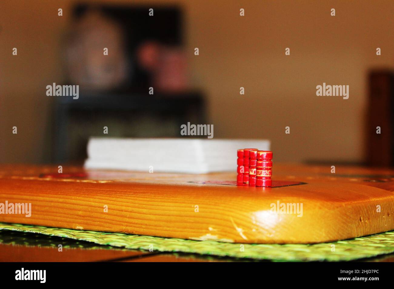 Primo piano di pioli in un tabellone Wampoo. Un mazzo di carte si trova al centro del tabellone. Foto Stock