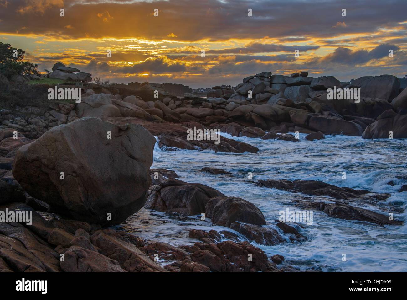 Rocce rosse sulla riva dell'oceano durante il tramonto Foto Stock