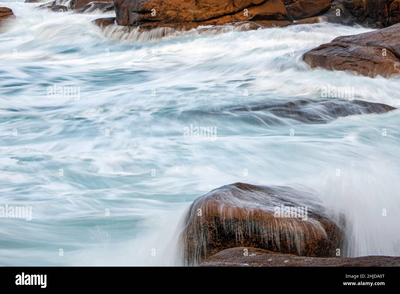 Le onde dell'oceano colpiscono le grandi pietre della costa rocciosa Foto Stock