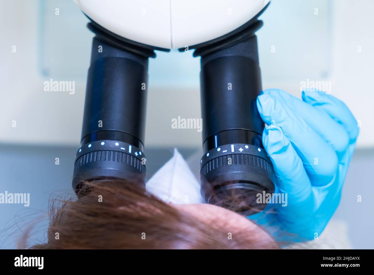 Scienziata femminile professionista che fa esperimento con microscopio elettronico in laboratorio di ricerca genetica scientifica Foto Stock
