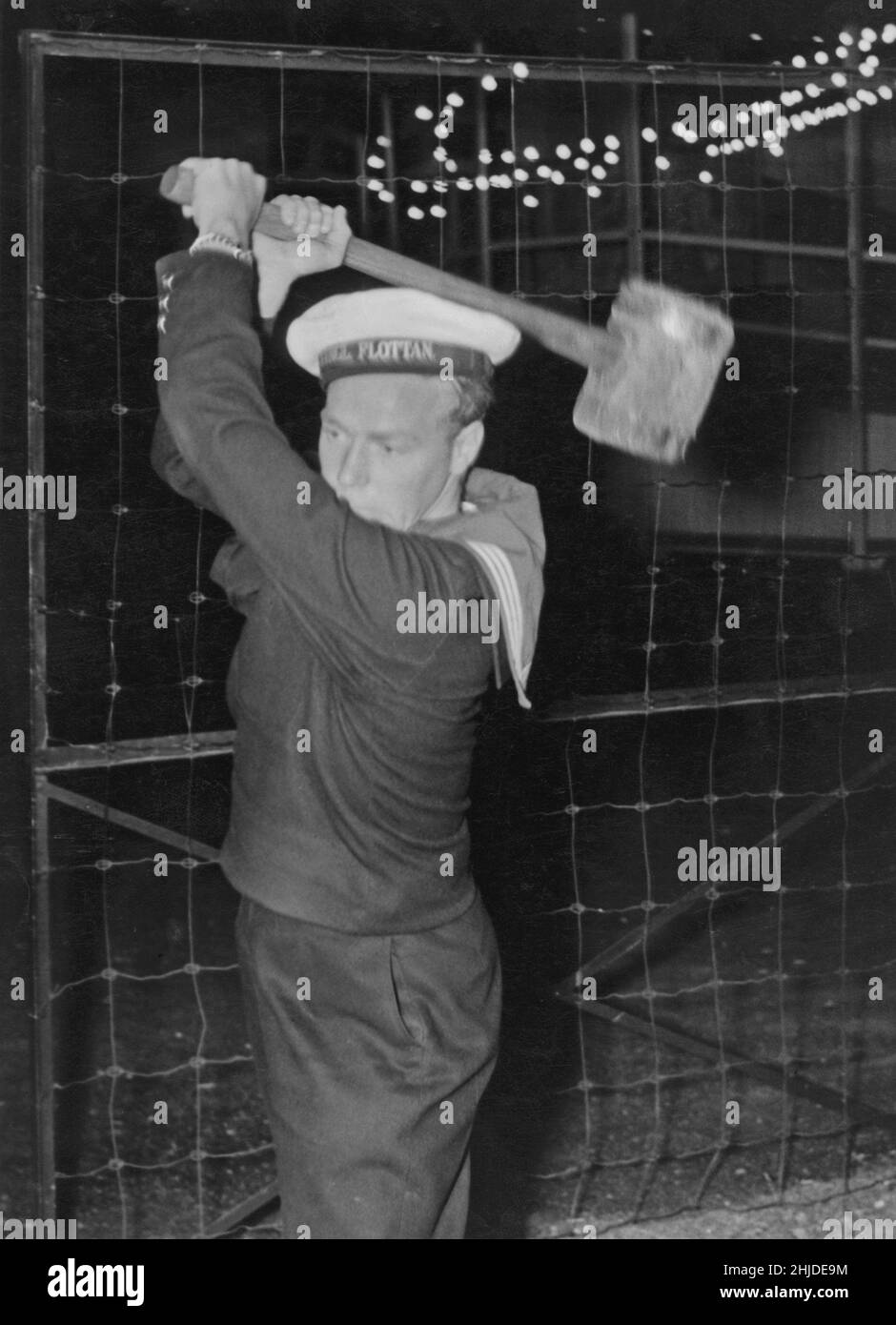 Parco divertimenti nel 1940s. Un marinaio svedese prova la sua forza alla macchina chiamata proprio quella; prova la tua forza. Con potenza e potenza sufficienti, la macchina emette un segnale che indica che si è raggiunta la parte superiore del contrassegno. Una cosa comune nei giorni scorsi. Foto Stock