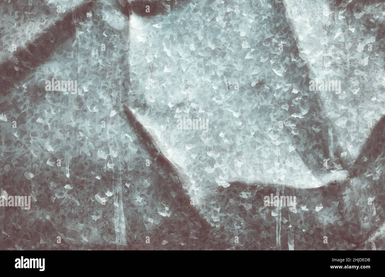 Immagine retrò colorata di un vecchio foglio di metallo piegato, sfondo grigio scuro astratto o texture. Foto Stock