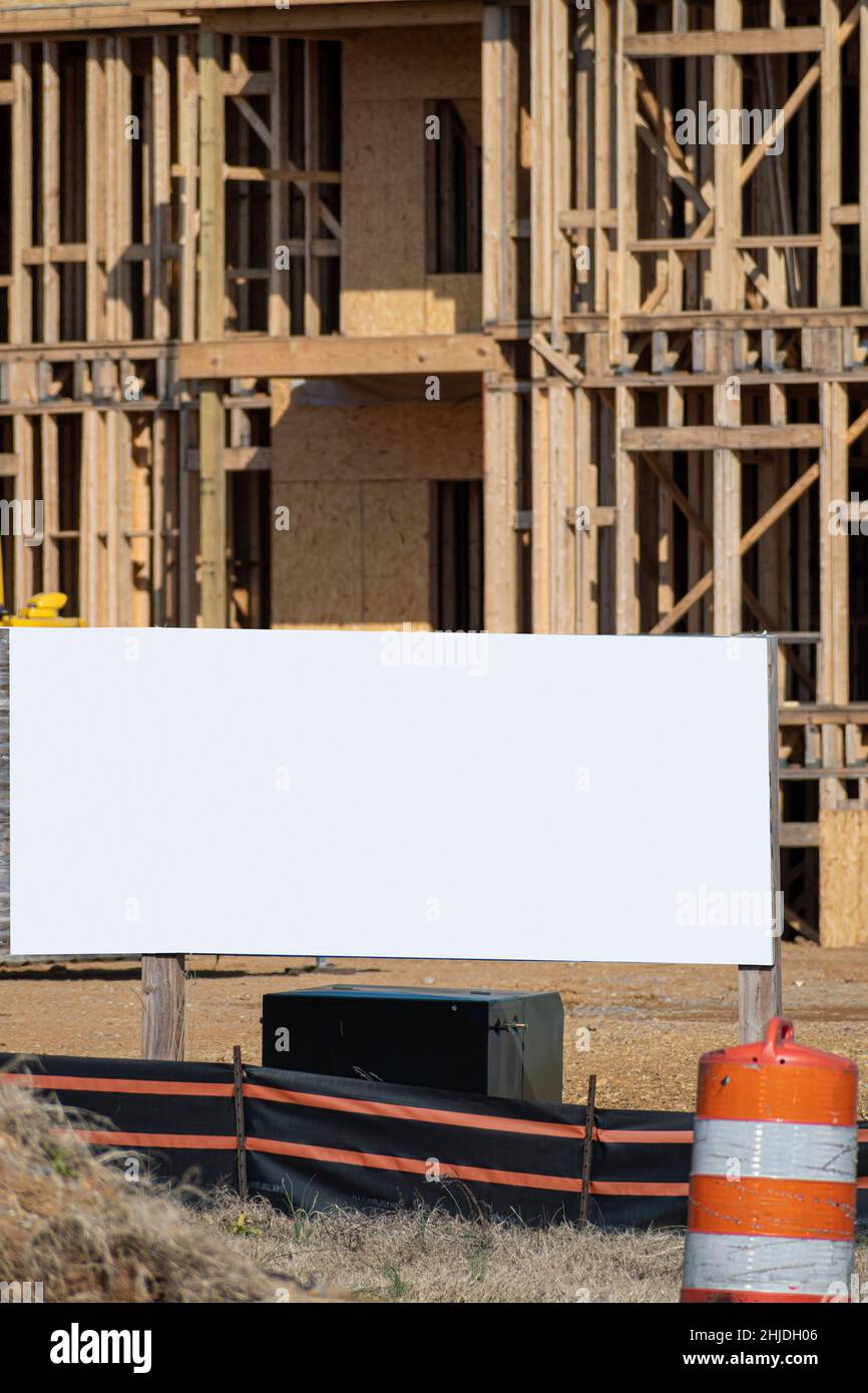 Scatto verticale di un grande segno bianco di fronte alla costruzione di un nuovo appartamento. Foto Stock