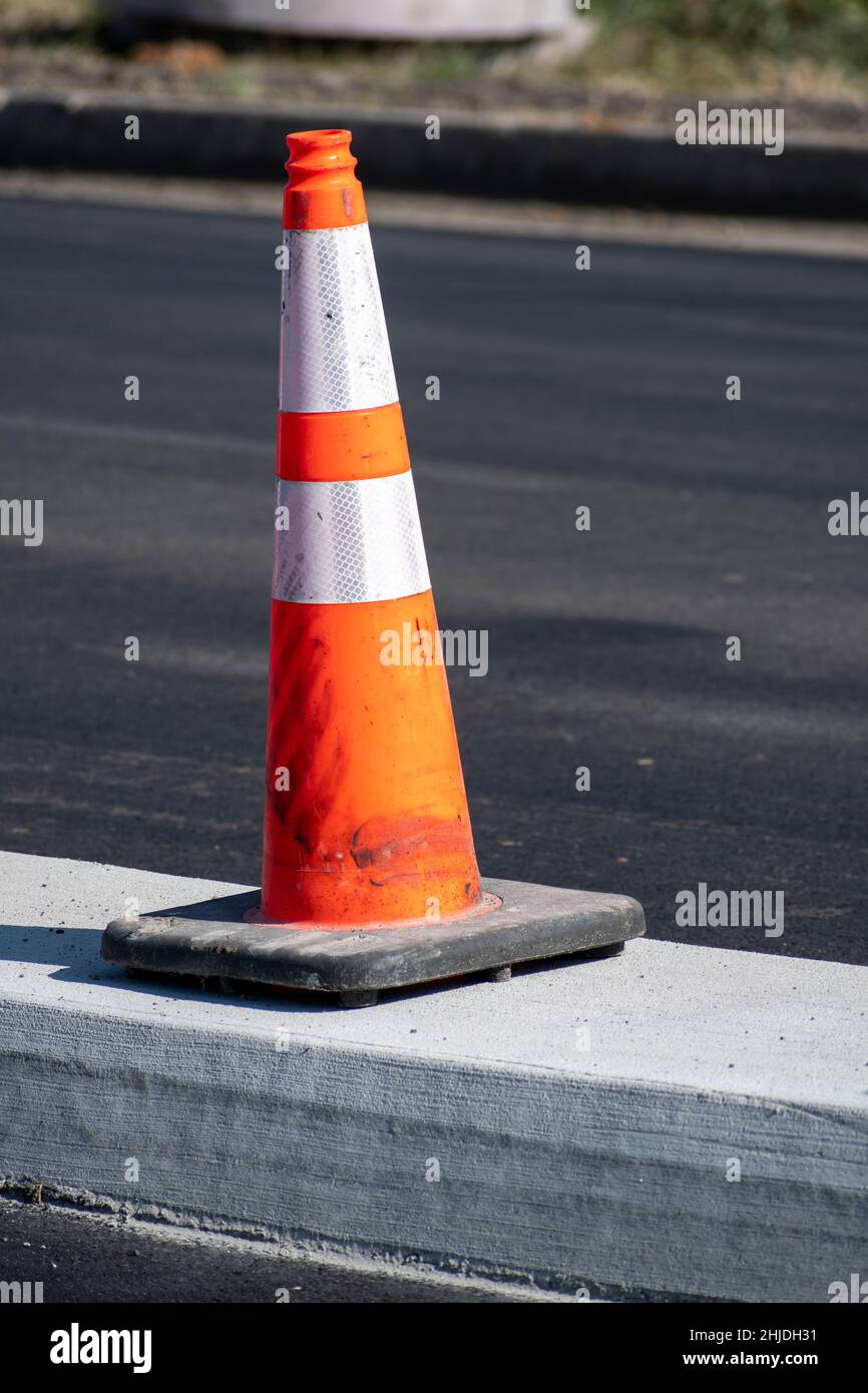 Colpo verticale di un cono di traffico arancione in occasione della nuova costruzione. Foto Stock