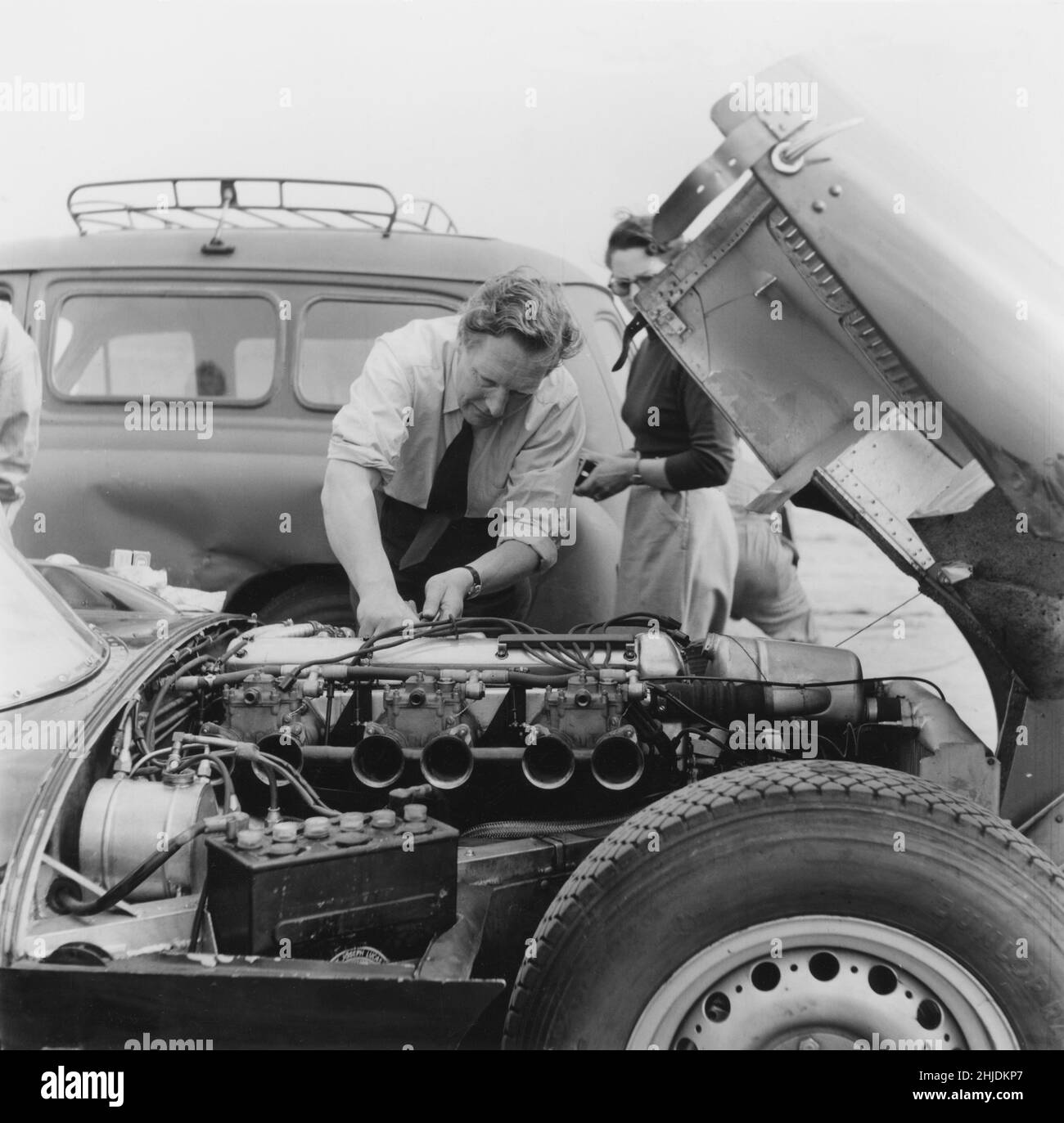 Auto da corsa del 1950s. Un uomo che lavora sul motore di una vettura da corsa durante una gara del Gran premio 1955 nella città svedese Kristianstad. Foto Stock