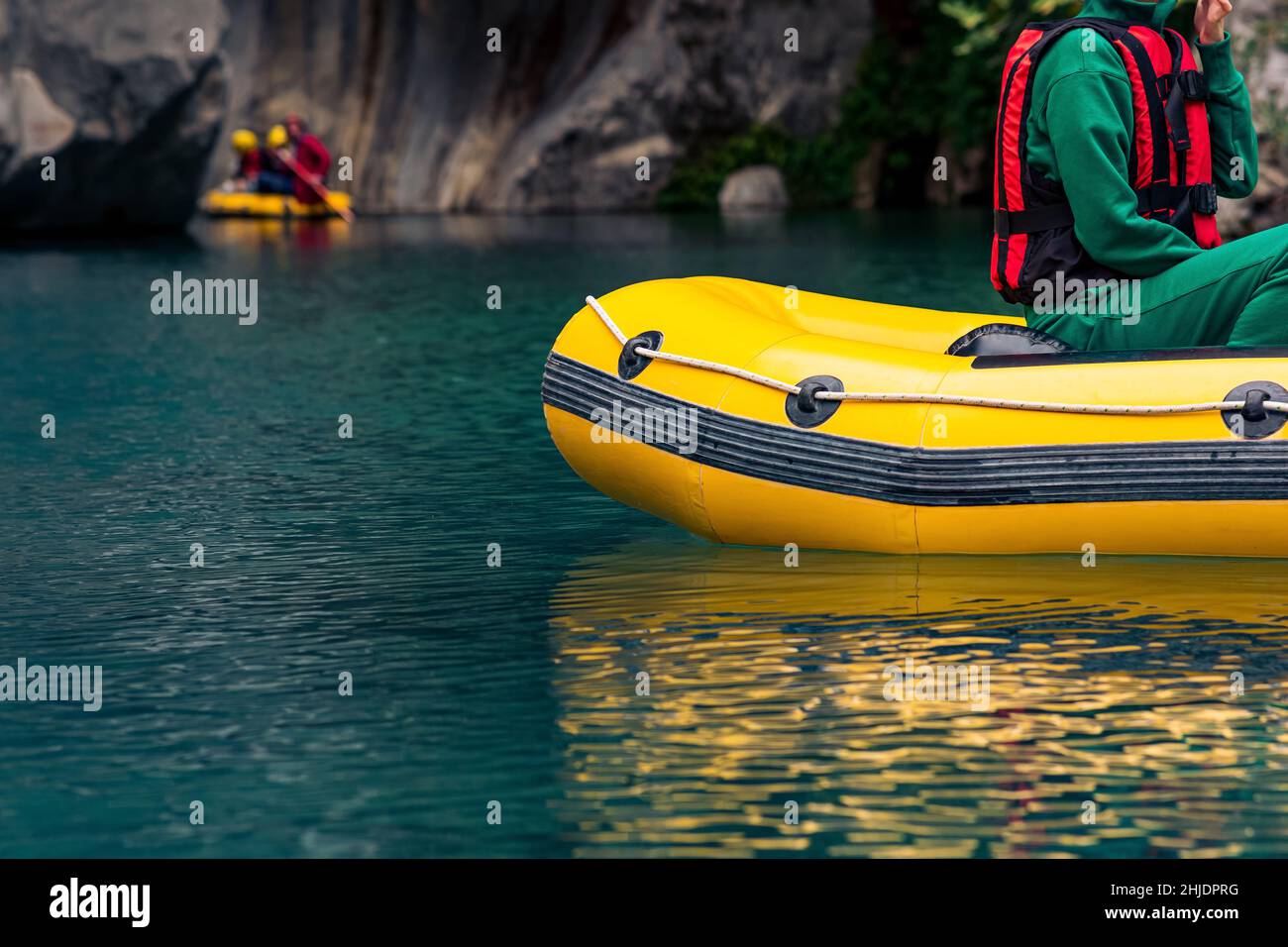 I turisti su una barca gonfiabile galleggiano lungo un canyon roccioso con acqua blu a Goynuk, Turchia Foto Stock