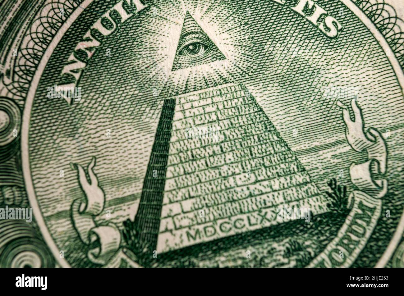 Denaro americano, illuminati e simboli mistici concetto con macro primo piano su tutto il vedere eyeball in cima alla piramide sul retro del dollaro americano Bill Foto Stock