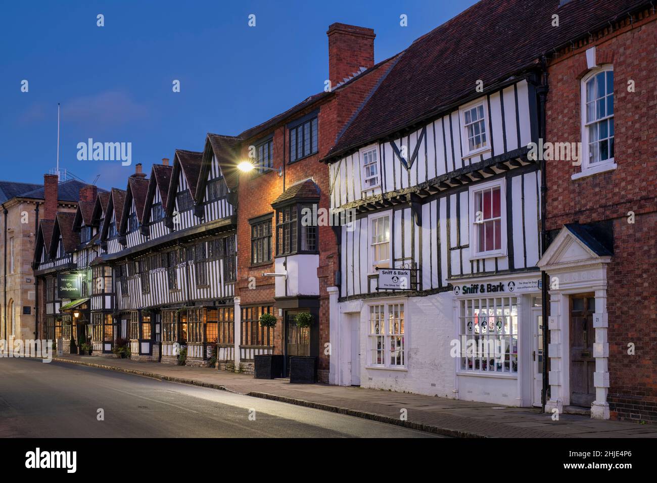 Legno incorniciato e mattoni edifici lungo la strada cappella al crepuscolo. Stratford upon Avon, Warwickshire, Inghilterra Foto Stock