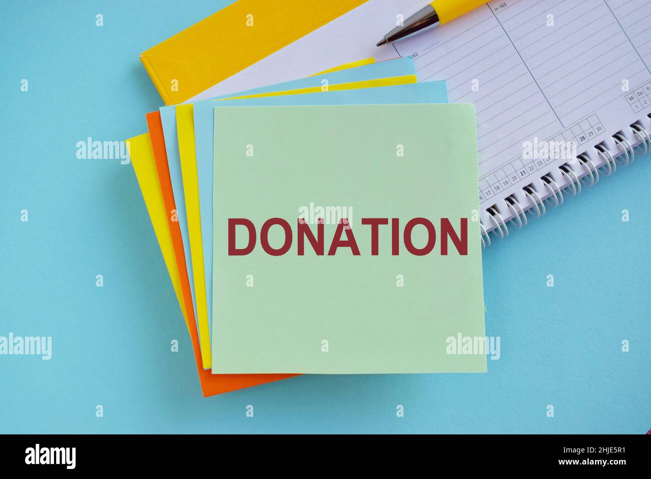 Concetto di donazione scritto sulla nota colorata dell'adesivo Foto Stock