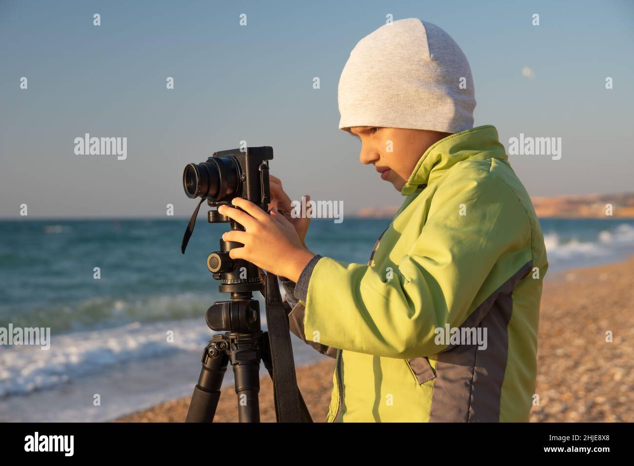 Un ragazzo giovane cerca di imparare e scattare foto. Foto Stock
