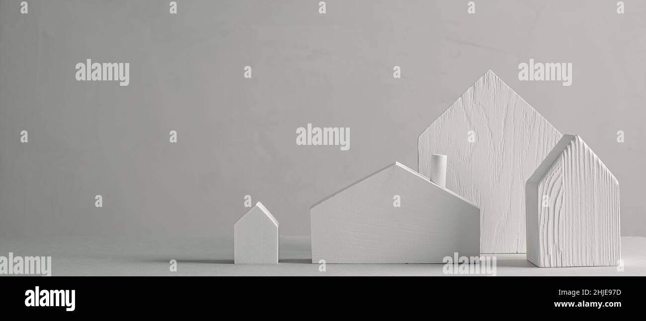 Case giocattolo bianche in legno su sfondo grigio. Design minimalista decorativo scandinavo Foto Stock