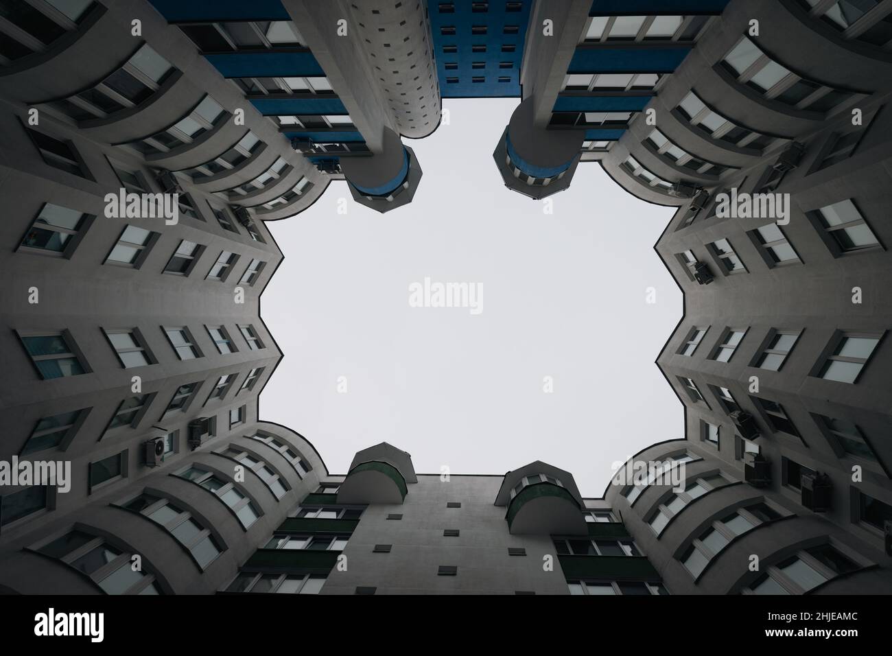 vista dal basso delle nuvole grigie nel cielo tra vecchia casa in mattoni nella grande città in inverno sera cortile-bene Foto Stock