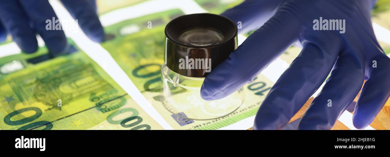 Un esperto di guanti verifica l'autenticità delle banconote in euro Foto Stock