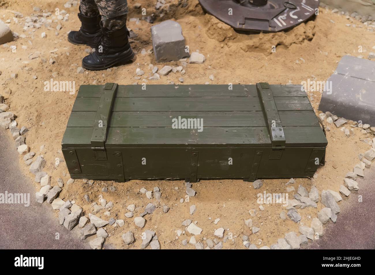 Una scatola verde con munizioni militari sulla sabbia. Assistenza militare. Forniture militari. Foto Stock