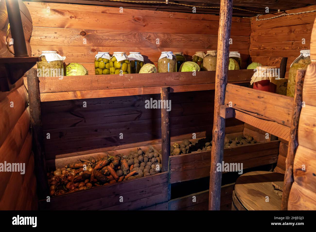 Conservazione delle verdure in una cantina calda per il periodo invernale. Vasetti di vetro con cetrioli sottaceto sulla mensola. Foto Stock