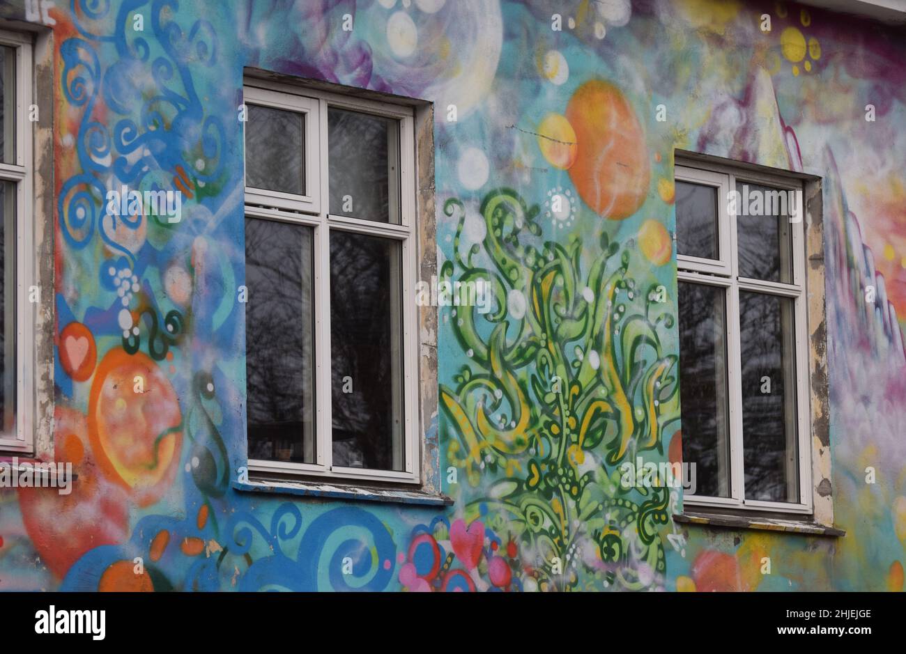 Un primo piano delle finestre e delle pareti del piano superiore di un bellissimo edificio dipinto da graffiti colorati a Reykjavík Islanda. Street art reyjkyavik Foto Stock