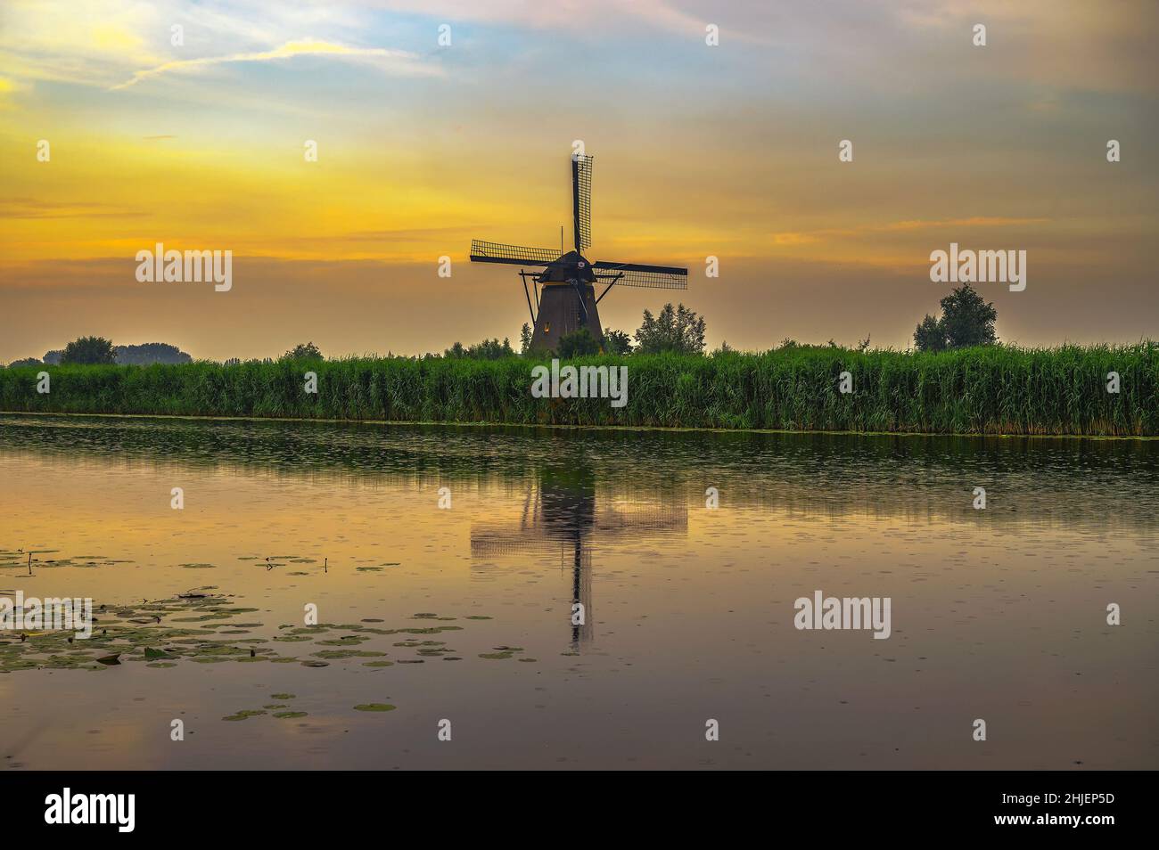 Il vecchio mulino a vento olandese al tramonto in Kinderdijk, Paesi Bassi Foto Stock
