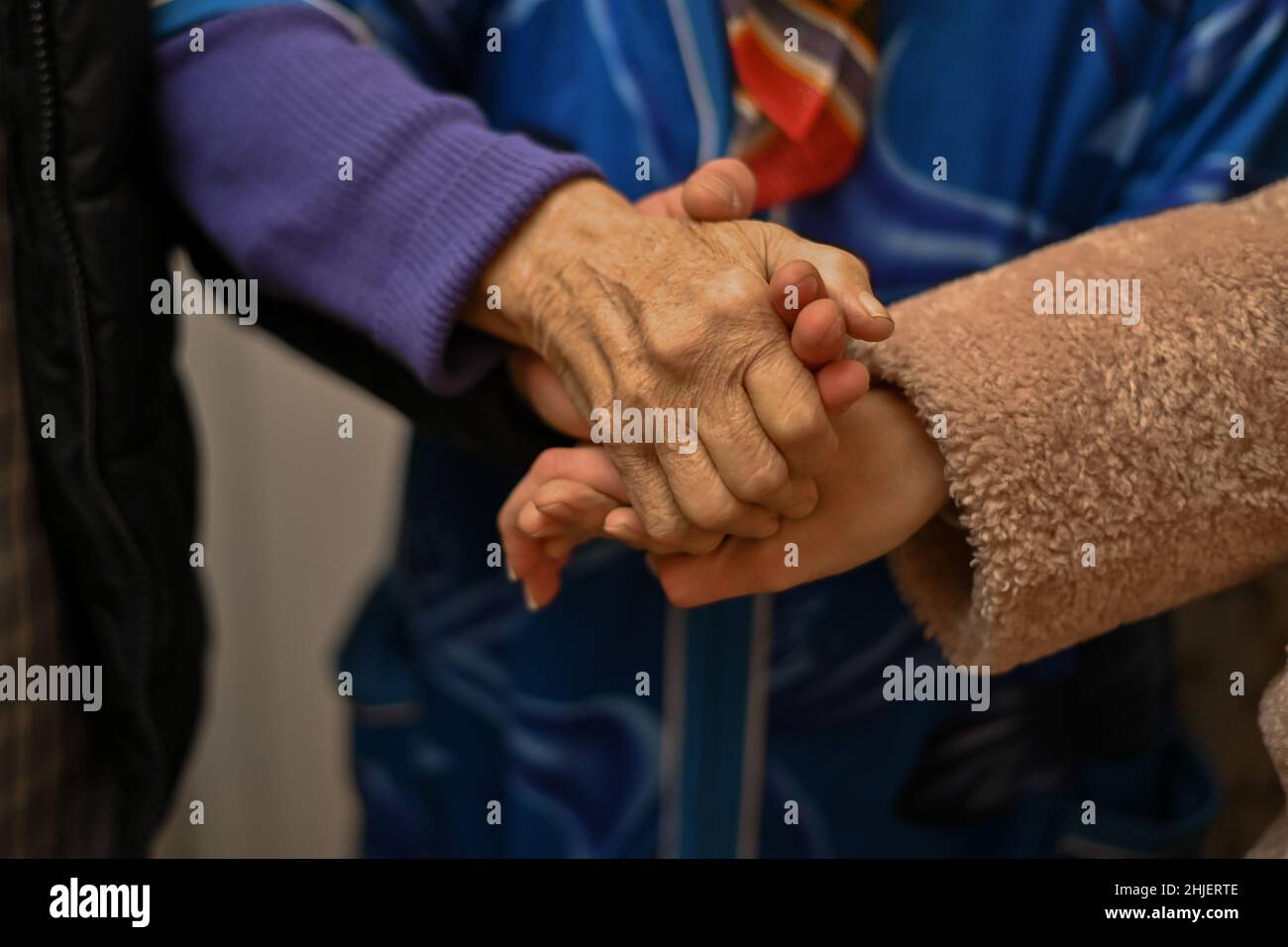 nonne che tengono le mani di giovani uomini e donne Foto Stock