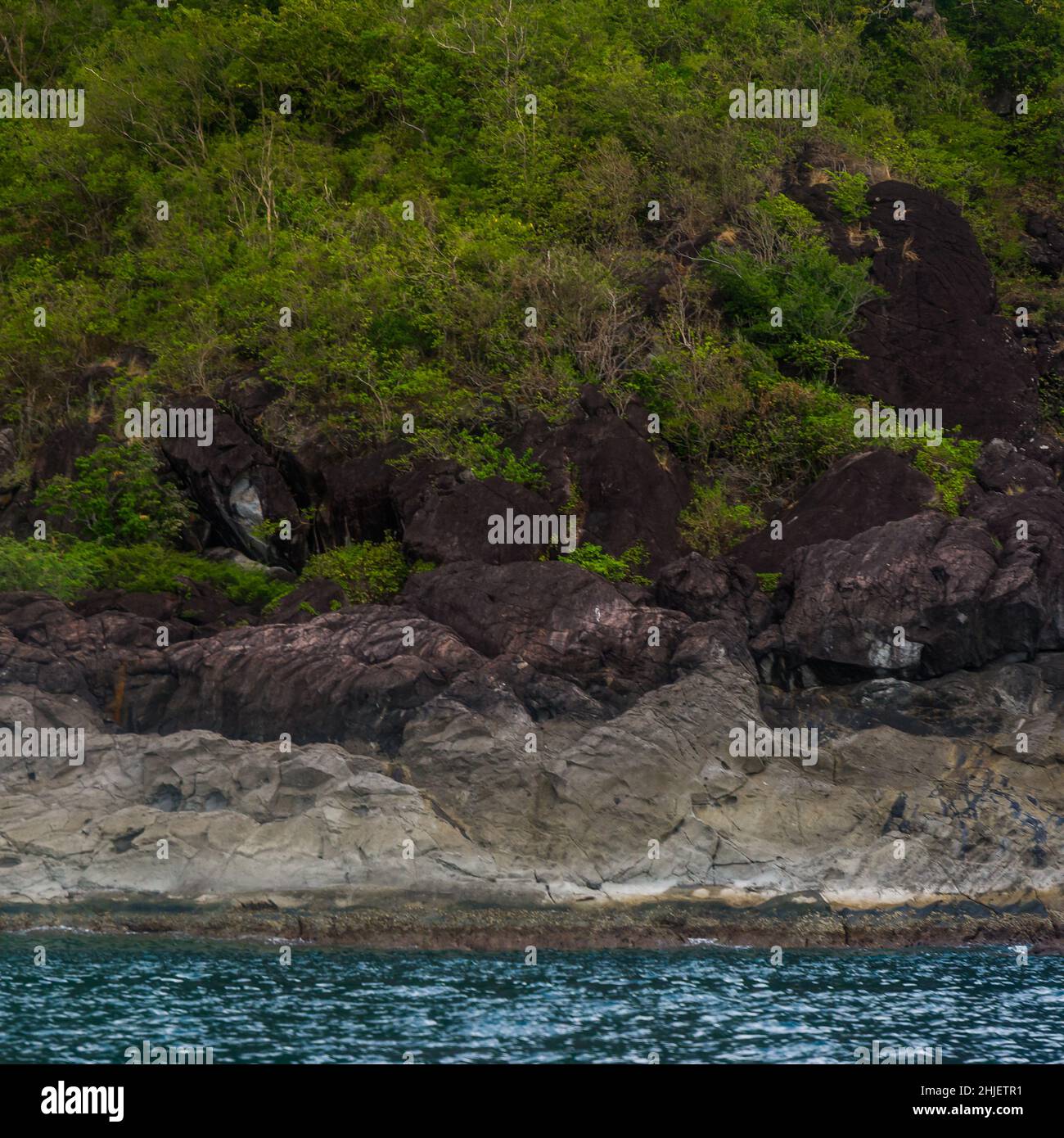 Rock Island su scenografica acqua di mare blu e cielo sovrastato Foto Stock