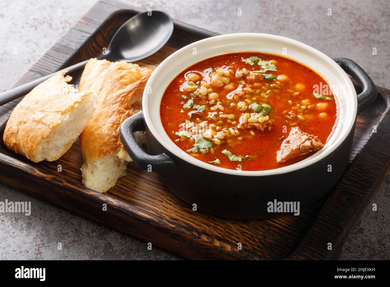 Zuppa tradizionale Chorba Frik a base di agnello, Freekeh e verdure da vicino in un piatto sul tavolo. Orizzontale Foto Stock